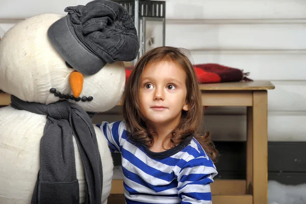 Menina com um boneco de neve de brinquedo — Fotografia de Stock