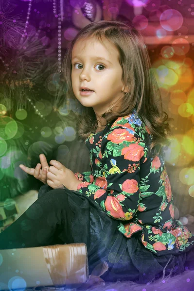Little girl with gifts near a Christmas tree — Stock Photo, Image