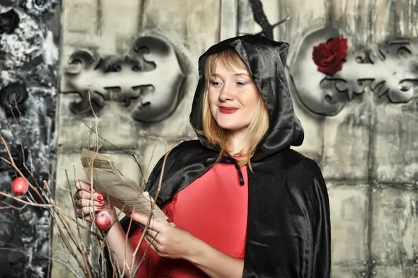 Donna in abito rosso e mantello nero con cappuccio ad Halloween — Foto Stock