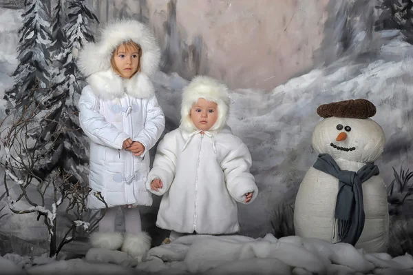 Two little girls in white coats and white fur hats — Stock Photo, Image