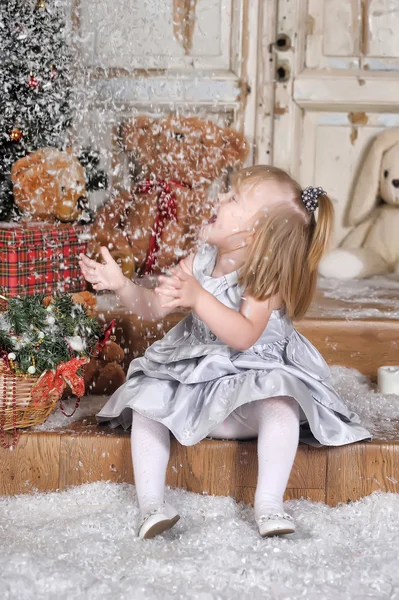 Menina jogando neve falsa — Fotografia de Stock