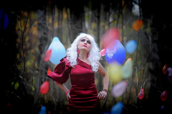 Mooie jonge vrouw in het beeld van de heks in het bos op halloween. — Stockfoto