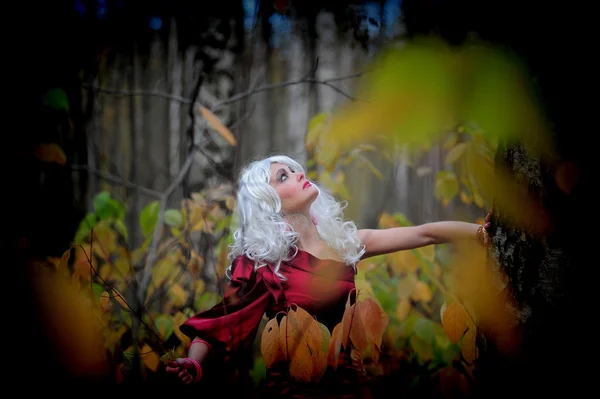 Vacker ung kvinna i bilden av häxan i skogen på halloween. — Stockfoto