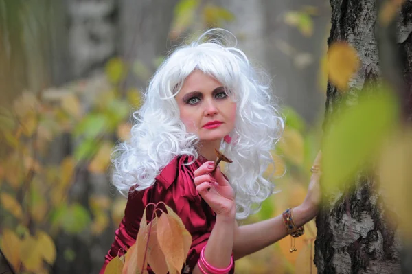 Mooie jonge vrouw in het beeld van de heks in het bos op halloween. — Stockfoto