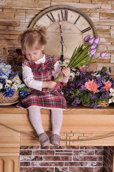 Kleines Mädchen mit einem Strauß Tulpen in den Händen — Stockfoto