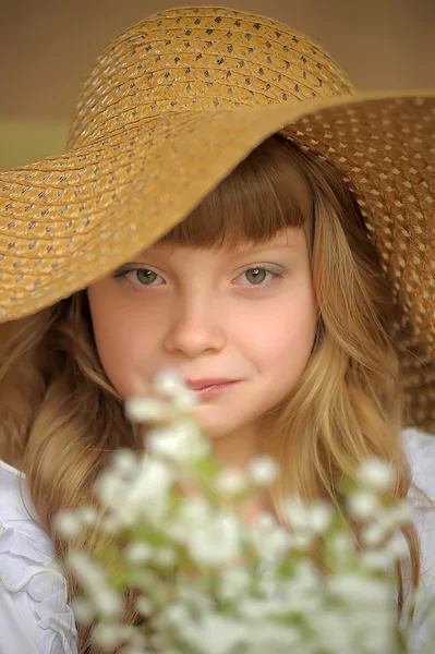 Девушка в соломенной шляпе с букетом лилий долины — стоковое фото