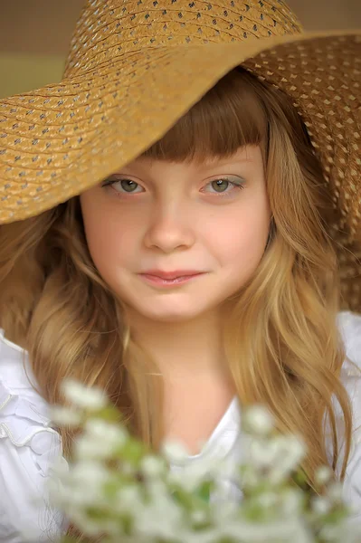 Girl in a straw hat with a bouquet of lilies of the valley — Stock Photo, Image