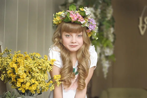 Beautiful young blond girl in a wreath of flowers — Stock Photo, Image