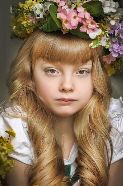 Menina loira bonita em uma grinalda de flores — Fotografia de Stock