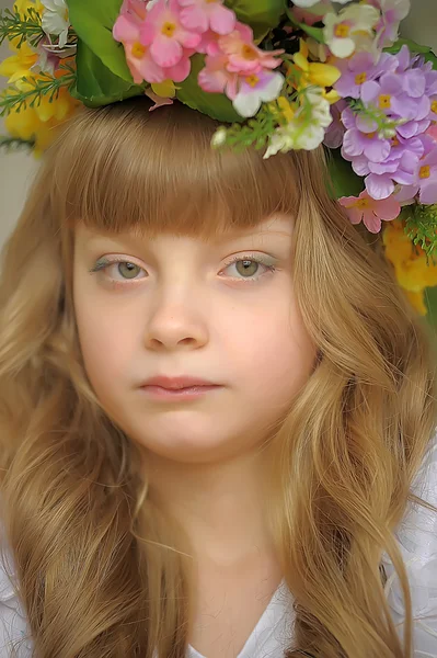 Menina loira bonita em uma grinalda de flores — Fotografia de Stock