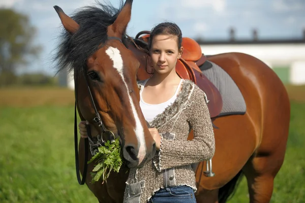 Beautiful young teen girl with the brown horse — Stock Photo, Image