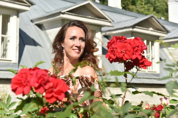 Hermosa Mujer Morena Con Rosas Rojas Cerca Del Arbusto Retrato — Foto de Stock