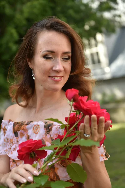 Piękna Brunetka Kobieta Czerwonymi Różami Pobliżu Krzaka Parku Portret — Zdjęcie stockowe