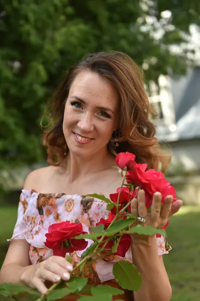 Parktaki Portrede Çalıların Yanında Kırmızı Gülleri Olan Güzel Esmer Kadın — Stok fotoğraf