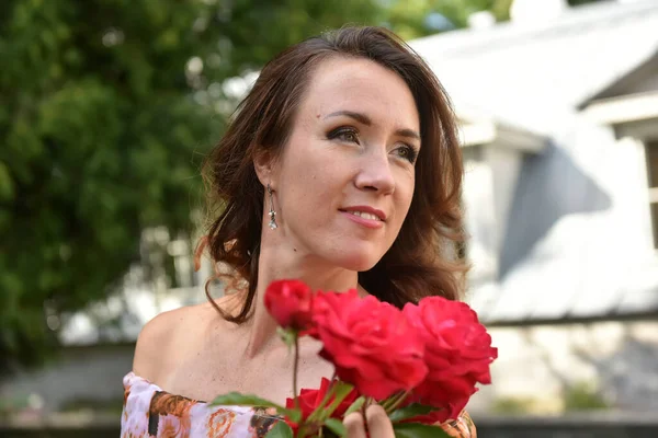 Parktaki Portrede Çalıların Yanında Kırmızı Gülleri Olan Güzel Esmer Kadın — Stok fotoğraf