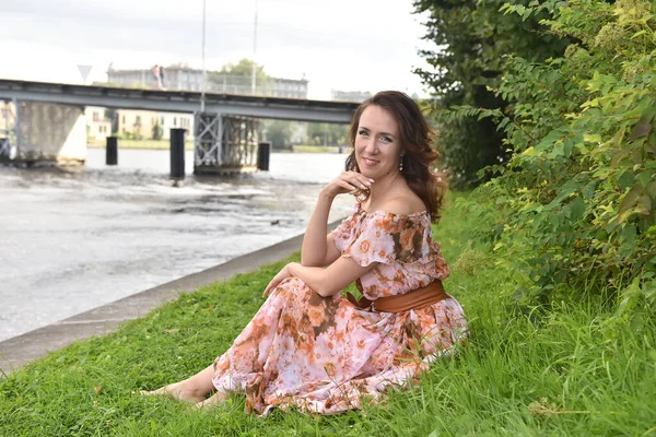 Bela Mulher Morena Vestido Rosa Senta Grama Junto Rio — Fotografia de Stock