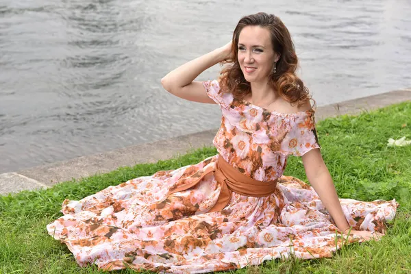 Beautiful Brunette Woman Pink Dress Sits Grass River — Stock Photo, Image