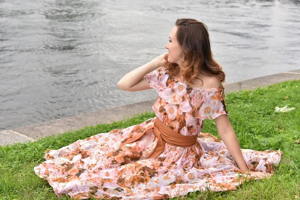 Красивая Брюнетка Розовом Платье Сидит Траве Реки — стоковое фото