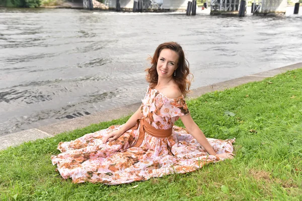 Beautiful Brunette Woman Pink Dress Sits Grass River — Stock Photo, Image