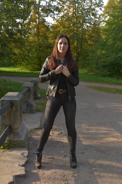 Siyah Deri Ceketli Esmer Kız Sonbahar Parkında Siyah Kot Pantolon — Stok fotoğraf