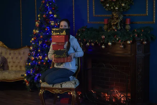 年轻的黑发姑娘 带着一盒盒的礼物来到圣诞树旁 — 图库照片