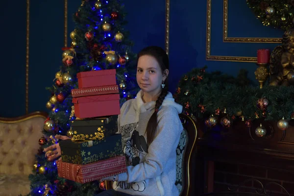 年轻的黑发姑娘 带着一盒盒的礼物来到圣诞树旁 — 图库照片