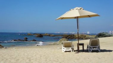Deniz kıyısı şemsiyesi altında sandalyeler