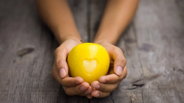 Gelber Apfel mit eingraviertem Herz — Stockfoto