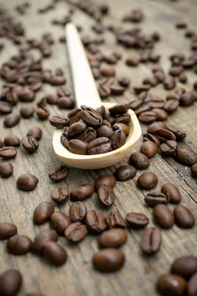 Cucchiaio di legno con chicchi di caffè — Foto Stock