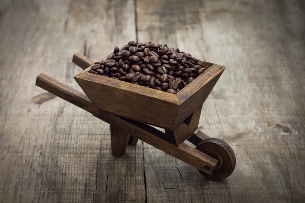 Кофейные зерна в тачке — стоковое фото