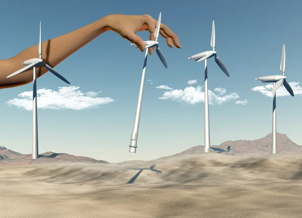 Hand placing wind turbines in a desert — Stock Photo, Image