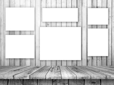 3D render of a wooden table looking out to a wall of blank pictures
