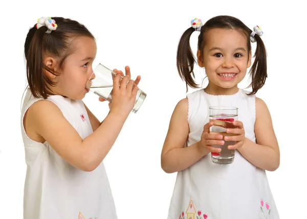 Leende liten flicka med ett glas vatten på en vit bakgrund — Stockfoto