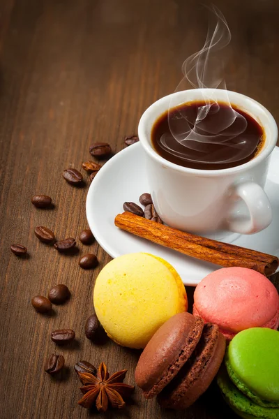 Tazza da caffè e macarone su un tavolo di legno. Sfondo scuro . — Foto Stock