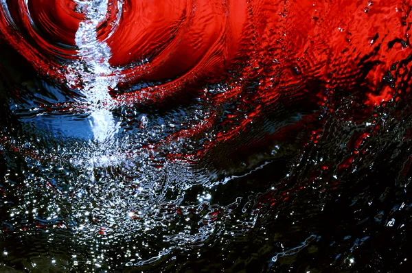 El agua corre sobre un fondo rojo-azul — Foto de Stock