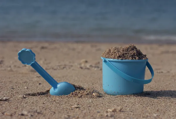 Pequeño cubo de arena en la orilla del mar — Foto de Stock