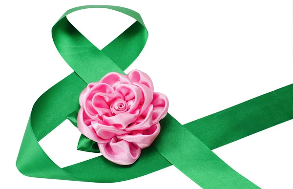 Green satiny tape combined in figure eight and an artificial flo — Stock Photo, Image