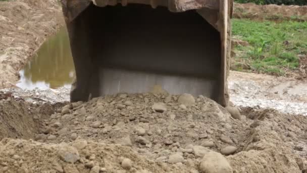 Primer plano de un cucharón excavador excavando en la suciedad — Vídeo de stock