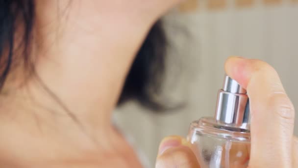 Frau spritzt Parfüm an ihren Hals