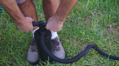 çimenlerin üzerinde hava pompası kullanan adam