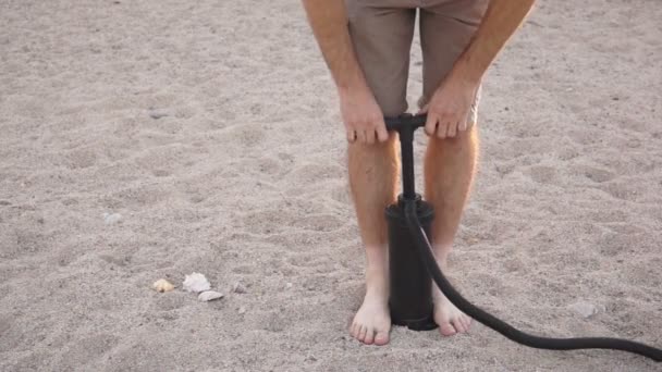 Mannen med luftpump på sandstranden — Stockvideo