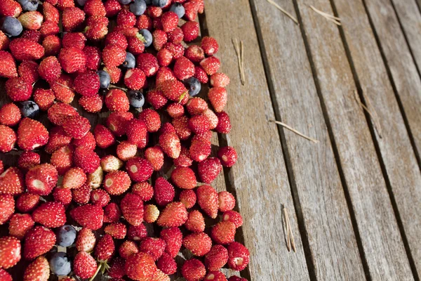 Yabani çilek ve bilberry tahta masada vardır — Stok fotoğraf