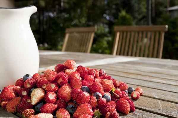 Yabani çilek ve bilberry tahta masada vardır — Stok fotoğraf