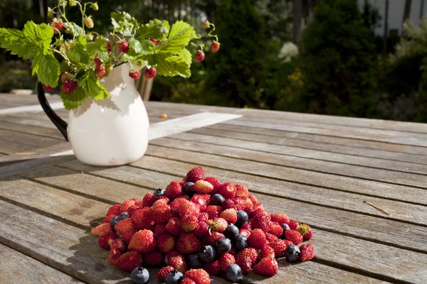 Wilde aardbei en blauwe bosbessen zijn op houten tafel — Stockfoto