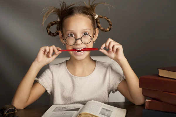 Chica de ocho años con libros cerca de la mesa — Foto de Stock