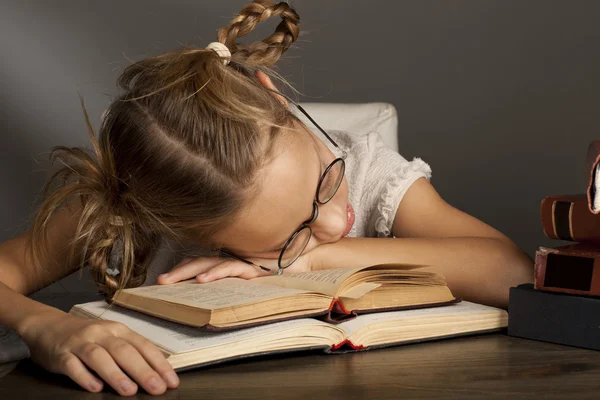 8 años chica es sleepingis en el libro —  Fotos de Stock