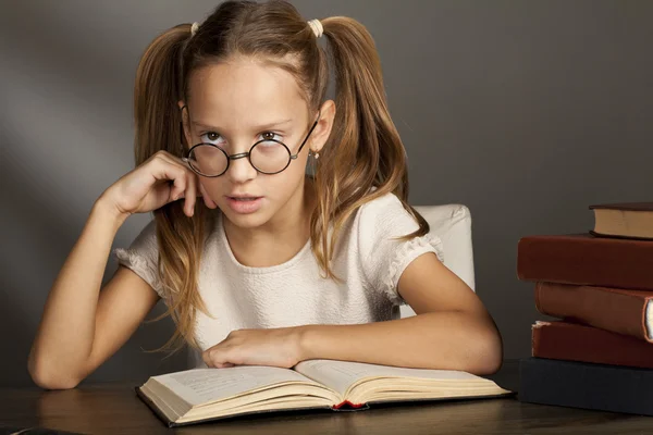 Chica de ocho años con libros cerca de la mesa — Foto de Stock