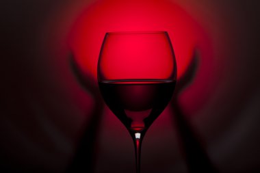 elle kırmızı ve siyah arka plan üzerinde kırmızı şarap cam