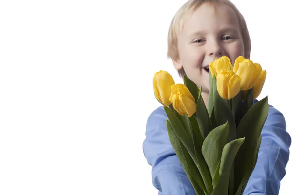 Fuori fuoco ragazzo presenta tulipani gialli — Foto Stock