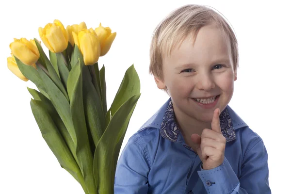 Menino sorridente com tulipas amarelas — Fotografia de Stock